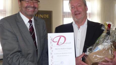 Bürgermeister Manfred Wolf (links) gratuliert Geschäftsführer Hubert Geiger zum Dienstjubiläum.  	 	
