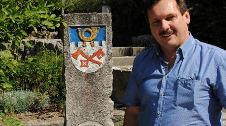 Bürgermeister Paul Reithmeir weist im Gemeindegarten auf einen Stein mit dem Eurasburger Wappen hin.  	Fotos: Christine Hornischer