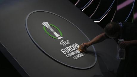 Ein Mitarbeiter reinigt das Logo der UEFA Europa Conference League.