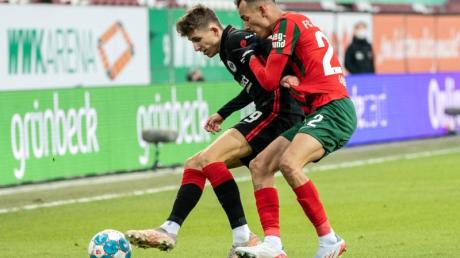 Jesper Lindström von Eintracht Frankfurt (l) und Iago von Augsburg kämpfen um den Ball.