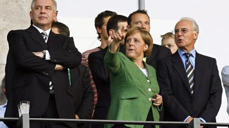 Die damalige Kanzlerin Angela Merkel (M) und Franz Beckenbauer (r) bei einem Spiel der WM 2006 in Deutschland.