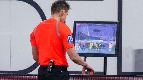 Schiedsrichter Daniel Siebert überprüft ein Handspiel per Videobeweis.