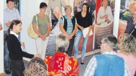 Carmen Schüller (links) von Stellwerk erklärt die Ausstellung „Die Ehrenamtlichen im Bild“. 