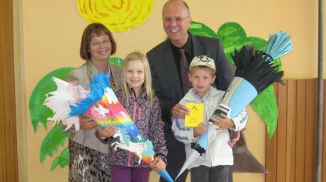 Romy und Hosea-Michael freuen sich zusammen mit der Rektorin der Burtenbacher Grundschule, Hannelore Lukas, über die Leseausweise für die Bücherei, den Bürgermeister Roland Kempfle jedem Erstklässler geschenkt hat. 
