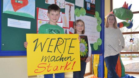 Die Grundschule und Mittelschule Offingen hat einen Wertekalender entwickelt. Passend dazu gibt es eine monatlich wechselnde Ausstellung. Die Drittklässler Moritz Schwarz und Ella Sauerzapf  mit Religionslehrerin Nathalie Charlet (von links).