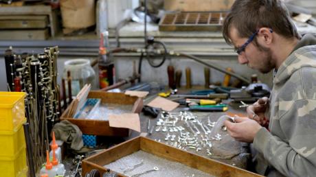 Aufwändige Kleinarbeit: Mitarbeiter Manuel Kleiber klebt Kork- und Filzplättchen auf die Metallklappen.  