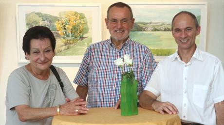 Die Ausstellung von Jürgen Graf (Mitte) ist im Therapiezentrum Burgau eröffnet worden. Links im Bild zu sehen ist seine Frau Ingrid und rechts Peter Miller, Leiter des Pflegedienstes. 	