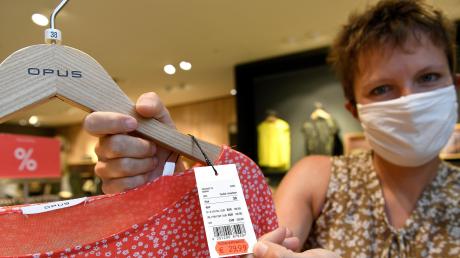 Judith Ganser vom Modehaus Schild in Günzburg zeigt ein stark reduziertes Kleidungsstück. Das Unternehmen gibt die Mehrwertsteuer-Absenkung bis zum Jahresende in Form von Rabattcoupons an die Kunden weiter. 