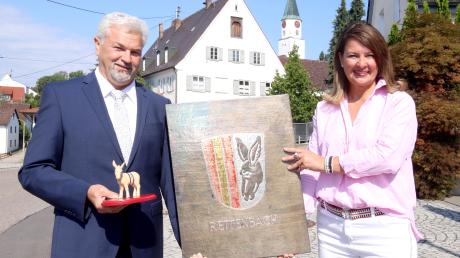 Rettenbach, Harthausen und Remshart haben sich vor 50 Jahren zusammengeschlossen. Bürgermeisterin Sandra Dietrich-Kast und Zweiter Bürgermeister Alexander von Riedheim mit dem Wappen der Gemeinde sowie dem Wappentier, dem Esel „Andi“, vor dem Rettenbacher Schlössle. 	