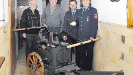 Peter Seidel und Werner Katheininger (von links) haben die Handpumpe aus dem Jahr 1876 restauriert. Mit im Bild: Kommandant Hubert Kramer und der Vorsitzende des Feuerwehrvereins Peter Weixler.  