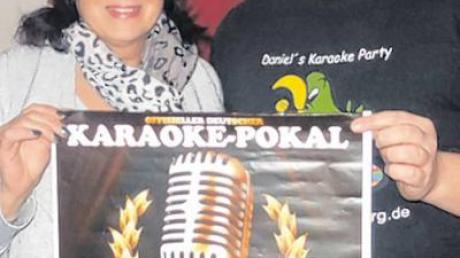 Pächterin Karin Habel und Karaoke-DJ Daniel Hab präsentieren das Plakat zur Euroke-Vorausscheidung 2016 im Café Carina.  	