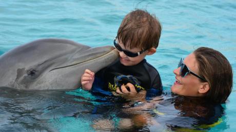 Ein Küsschen von Delfin „Bonnie“ – da könnte sich wohl kaum einer ein Lächeln verkneifen. Für Niclas Entwicklungsverzögerung war die Delfin-Therapie auf Curaçao sehr hilfreich, jetzt sparen seine Eltern für eine zweite Therapie. 
