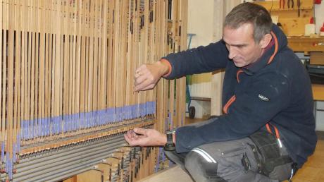 Orgelbauer Stefan Heiß in Aktion: Die Mechanik der Orgel wird reguliert. Diese Mechanik verbindet quasi die Tastengriffe des Organisten mit den Ventilen hinter den Pfeifen.