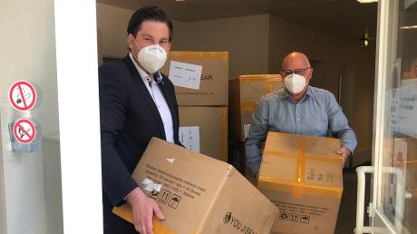 Rolf Gramm (rechts) übergibt Masken an Alexander Paul von der  Theresia-Hecht-Stiftung. Seine Zulieferer in China haben ihm 40000 Exemplare geschickt.  	