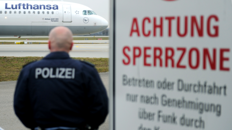 Ein Beamter der Bundespolizei beobachtet auf dem Flughafen in München (Oberbayern) ein Flugzeug auf dem Rollfeld. 