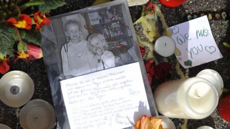 Blumen und Kerzen sowie ein Foto vor dem Haus in Krailling in dem zwei Geschwister grausam ermordet wurden. dpa