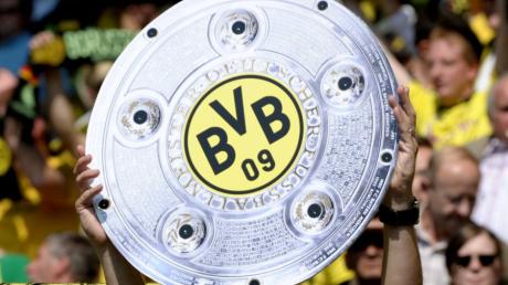 Ein Dortmunder Fan hält schon vor dem Spiel eine Kopie der Meisterschale in die Höhe.
