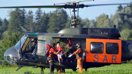 Ein Bergretter hebt bei Schwangau ein Mädchen aus einem Hubschrauber,  das von der Bergstation des Tegelbergs ausgeflogen wurde. Ein Gleitschirmflieger war zuvor in die Seile der Tegelbergbahn gestürzt