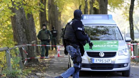 Maskierte Beamte eines Sondereinsatzkommandos der Polizei sichern den Augsburger  Siebentischwald ab.