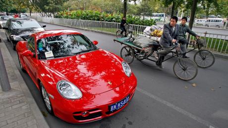 Während die reichen Chinesen Porsche fahren, können sich andere nur ein Fahrrad leisten.