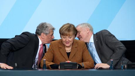 Was es da wohl zu tuscheln gibt? Joachim Gauck und Horst Seehofer hinter dem Rücken Angela Merkels.