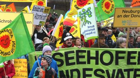 Menschen mit Fahnen und Transparenten sammeln sich am Sonntag vor dem Atomkraftwerk Gundremmingen zu einem Demonstrationszug. 