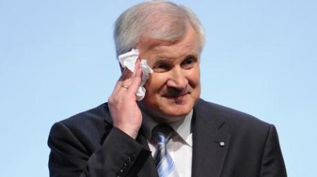 Der bayerische Ministerpräsident Horst Seehofer wischt sich den Schweiß von der Stirn. Foto: A. Gebert dpa