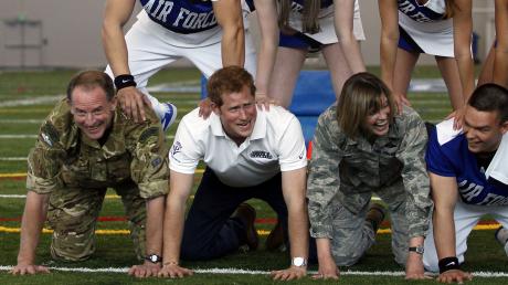 Prinz Harry besucht derzeit die USA. Er zeigt, dass auch staatsmänische Aufgaben Spaß machen können. Hier bei einer spontanen, menschlichen  Pyramide mit Cheerleadern und britischen Offizieren.  