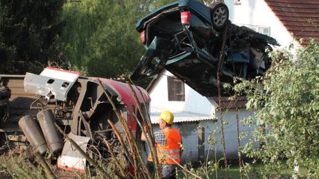Ein Zug hat in Kellmünz am Bahnübergang ein Auto erfasst. Der Zusammenstoß war so heftig, dass der Triebwagen und das Auto in Gärten landeten.