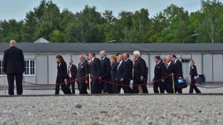 Bundeskanzlerin Angela Merkel (M) geht umringt von zahlreichen Begleitern über das Gelände des Konzentrationslagers Dachau. Der Besuch von Merkel (CDU) in der KZ-Gedenkstätte hatte schon vorab für Konfliktstoff gesorgt.