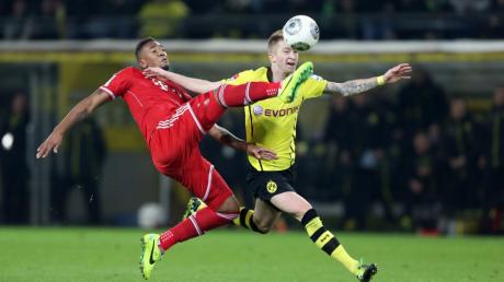 Münchens Jerome Boateng (links) kämpft gegen den Dortmunder Marco Reus um den Ball. Foto: Friso/dpa