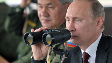 (FILES) A file picture taken on July 16, 2013, shows Russia's  President Vladimir Putin (R) and Defence minister Sergei Shoigu (L) watching military exercises in the Pacific Ocean near the Sakhalin island. Putin ordered yesterday snap combat readiness drills near the Ukrainian border, which raised fears of the Kremlin using its military muscle to sway the outcome of a three-month crisis that has pitted Moscow against the West in a Cold War-style confrontation over the future of the strategic nation of 46 million. AFP PHOTO/ RIA-NOVOSTI/POOL / ALEXEI NIKOLSKY