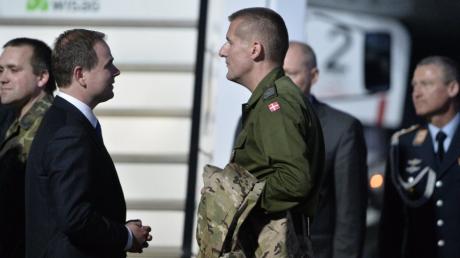Der dänische Verteidigungsminister Nicolai Wammen (l) unterhält sich am 03.05.2014 auf dem militärischen Teil des Flughafens Berlin-Tegel in Berlin mit dem freigelassenen OSZE Beobachter Oberstabsfeldwebel John Christensen. 