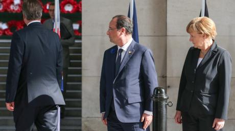 Angela Merkel und der französische Staatspräsident François Hollande blicken Premierminister David Cameron hinterher.