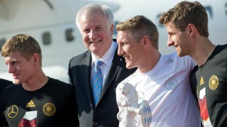 Der bayerische Ministerpräsident Horst Seehofer empfängt die Nationalspieler Toni Kroos (l-r), Bastian Schweinsteiger und Thomas Müller am Flughafen in München (Bayern). 
