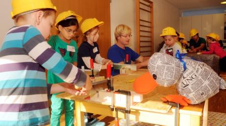 Unterweisung durch Baumeister Harry Hammer an der Werkbank: Paula Print und die Kinder des Kinderhauses St. Pankratius lernen, wie sie richtig mit Werkzeug umgehen.