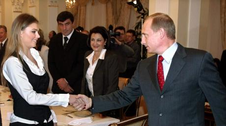 Alina Kabajewa schüttelt dem russischen Präsidenten Wladimir Putin (r.) die Hand