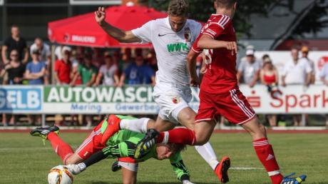 Lukas Welzmüller (Torwart SV Mering) fischt sich den Ball unter Tim Matavz (FC Augsburg).