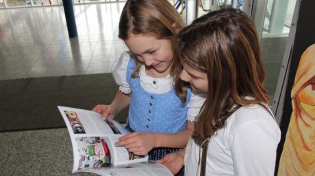 Die neunjährige Alina (links) und die zehn Jahre alte Katharina halten ihr neues Schulbuch in den Händen. 