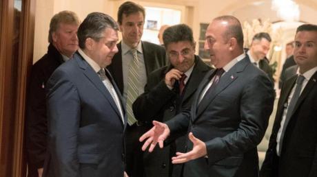 Außenminister Sigmar Gabriel spricht in Berlin an einem Ausgang des Hotels Adlon mit seinem türkischen Amtskollegen Mevlüt Cavusoglu.