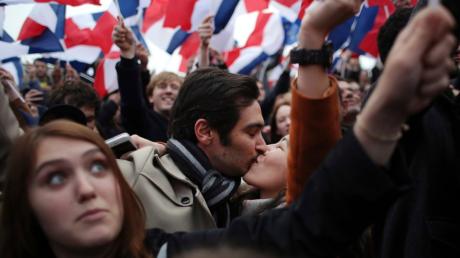Anhänger des Kandidaten Macron küssen sich am 07.05.2017, nachdem seine Konkurrentin Le Pen ihre Niederlage bei der Präsidentenwahl eingeräumt hat, vor dem Louvre in Paris Frankreich. Macron konnte die Stichwahl um das Präsidentenamt in Frankreich gegen Le Pen für sich entscheiden. Foto: Thibault Camus/AP/dpa +++c dpa - Bildfunk+++