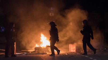Polizisten stehen in Hamburg im Schanzenviertel während des G20-Gipfels neben einer brennenden Barrikade.