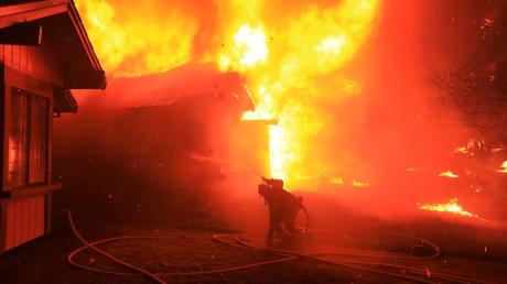Ein Feuerwehrmann kämpft in Santa Rosa gegen die Flammen eines brennenden Hauses.