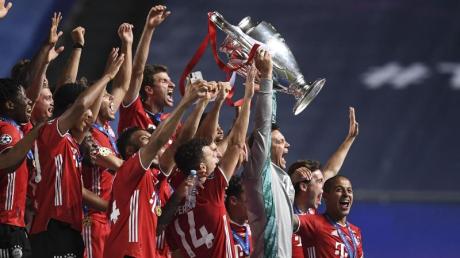 Bayerns Torhüter Manuel Neuer stemmt die Trophäe in die Höhe und jubelt mit dem Team.