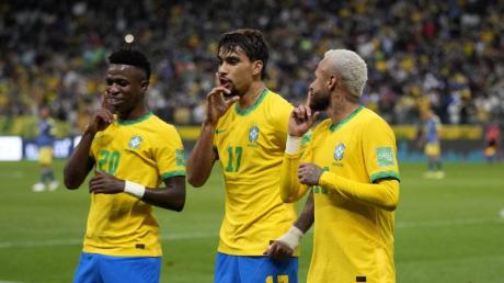 Der brasilianische Nationalspieler Lucas Paqueta (M) feiert mit seinen Teamkollegen Vini Junior. (l) und Neymar. 