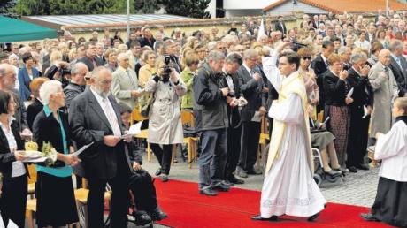 Ein großer Tag in Ursberg: Neupriester Bestle segnet bei der Primiz die zahlreich erschienenen Gäste. Links im Bild seine Eltern Hermine und Konrad.  