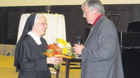 Pfarrgemeinderatsvorsitzender Josef Baur dankte Schwester Marianne Rauner mit einem Blumenstrauß für ihre Tätigkeit als Leiterin des Kinder- und Jugendchors.  