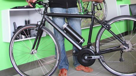 Dieses Rad  ist ein E-Bike, bestehend aus einem normalen Fahrrad, das entsprechend „frisiert“ wurde. Und das, was aussieht wie eine passende Trinkflasche, ist eigentlich der Akku. 