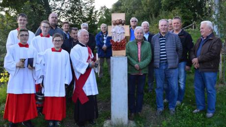 Die Evangelisten-Stele in Mindelzell: Links steht Diakon Alois Held und rechts der Künstler Wolfgang Klein, zusammen mit den Ministranten und den Kreuzweg-Helfern. 	