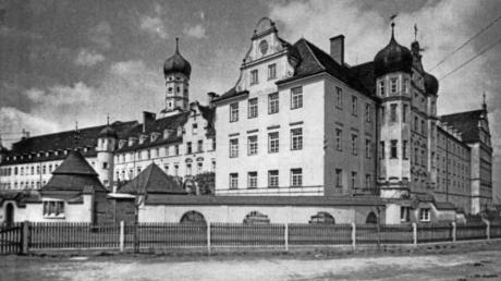 Das Ursberger Pflegehaus St. Josef mit einem Zaun, der „Erbkranken“ die Flucht erschweren sollte. Die Umzäunung war von den Behörden in den 1930er Jahren vorgeschrieben worden. 519 Menschen wurden von Ursberg aus in andere Einrichtungen verlegt. 379 davon starben.  